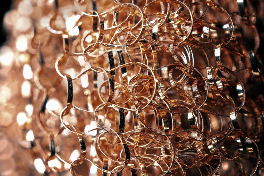 Entangled metal wire with rounded edges and glowing surface on blurred background in twilight
